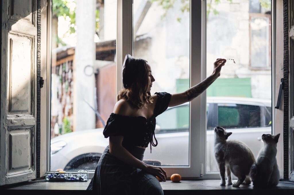 Pretty woman playing with siamese cats —