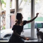 Pretty woman playing with siamese cats —