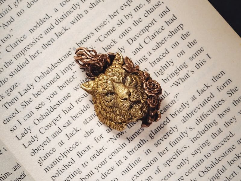 A figurine of a lion placed on the open pages of a book, symbolizing the lion's prominent role in literature and cultural stories