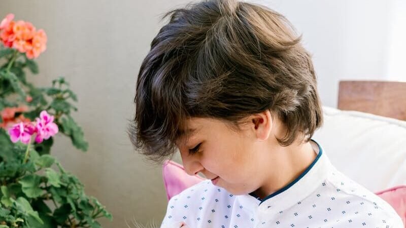 A young boy lovingly holds a cat indoors, showcasing affection and companionship.