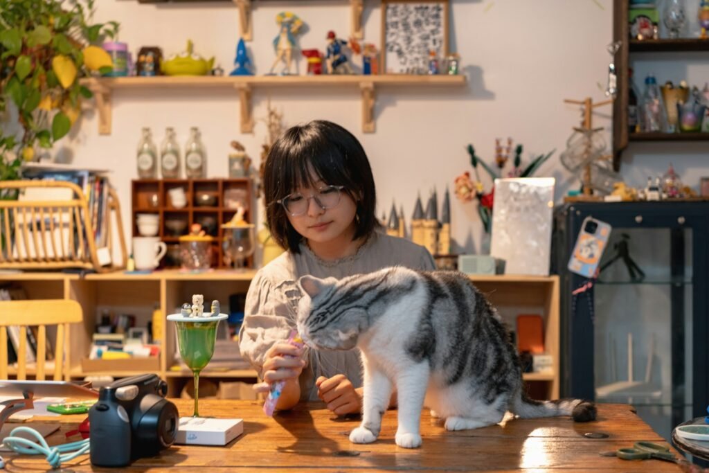 A woman sitting at a table with a cat