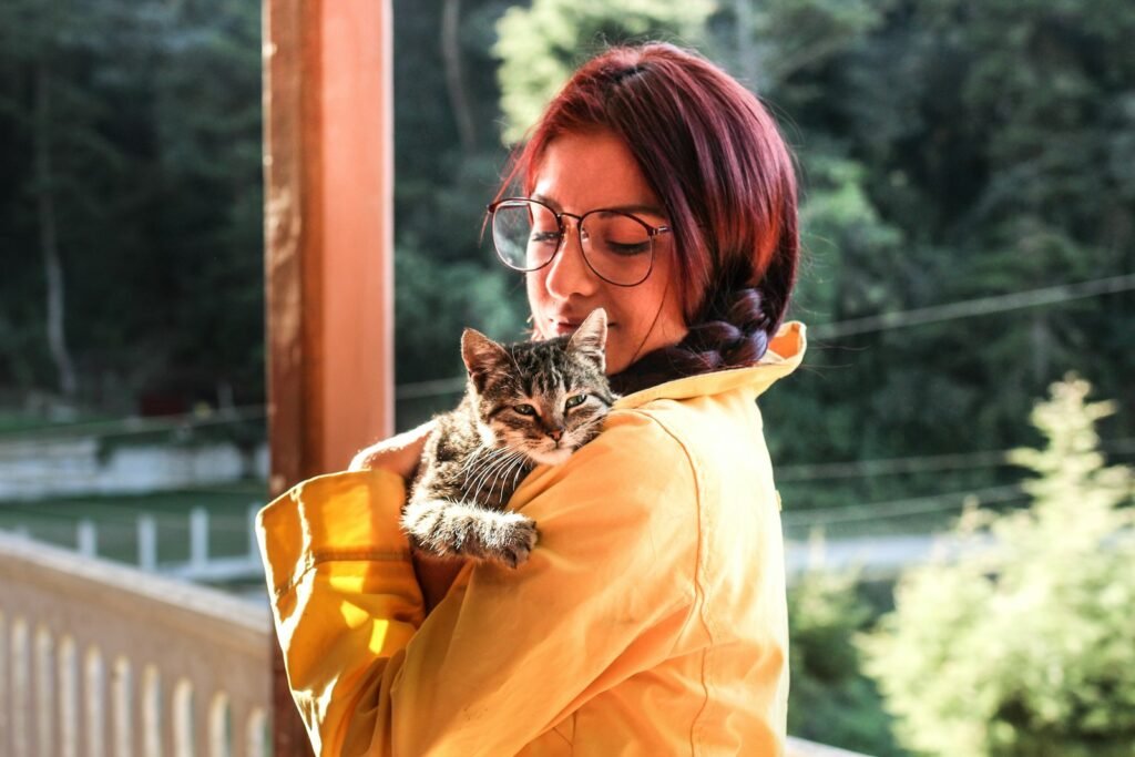 cat bond: woman carrying cat while standing on porch