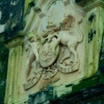 Intricate stone sculpture of a royal emblem on a historic building in Galle Fort, Sri Lanka.