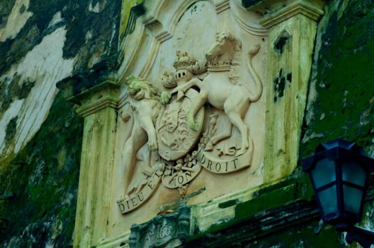 Intricate stone sculpture of a royal emblem on a historic building in Galle Fort, Sri Lanka.