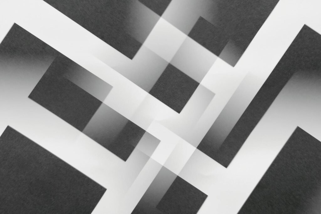Minimalist abstract geometric pattern in black and white with layered designs.