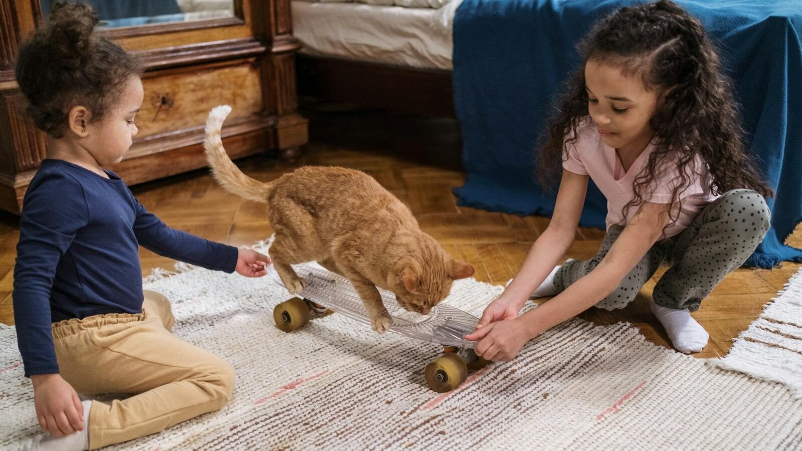 Two children playing with an orange cat in a cozy living room, engaging with toys and sharing a joyful moment