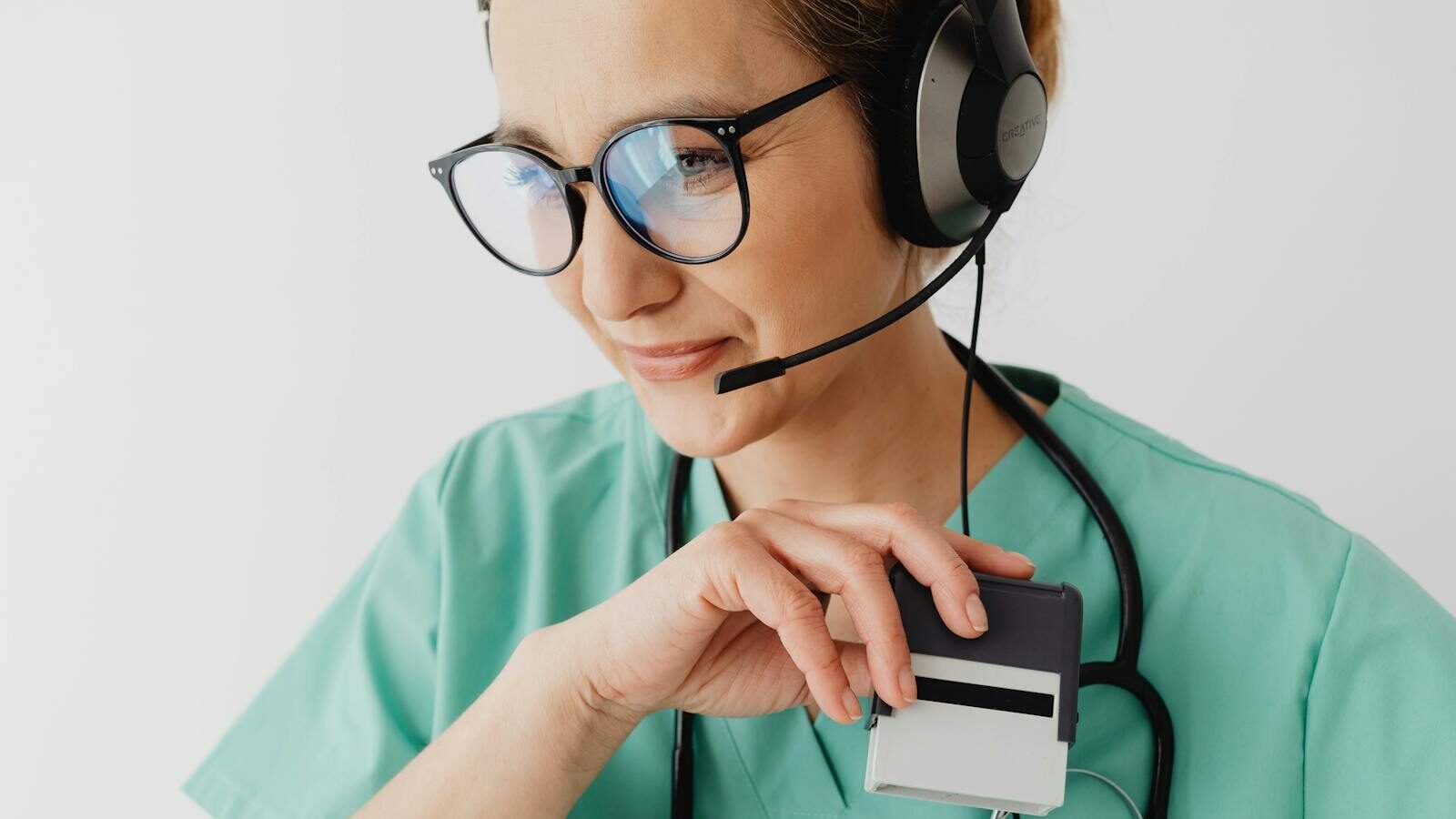 Medical professional with headset and stethoscope during a telemedicine consultation.
