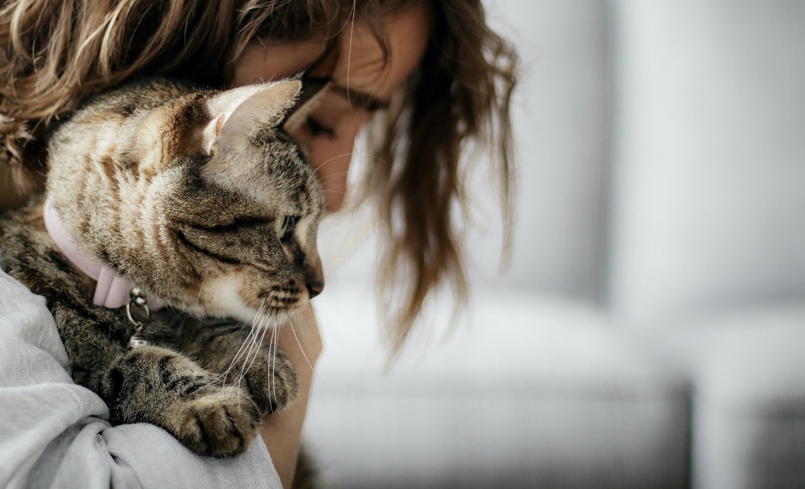 Photo by Nattalia Nuñez woman in white tank top carrying brown tabby cat