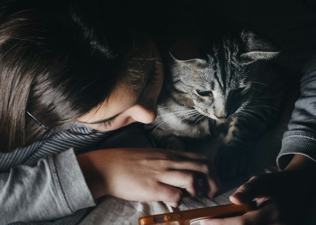 Cat Scent girl holding smartphone beside cat watching reclining to her shoulder