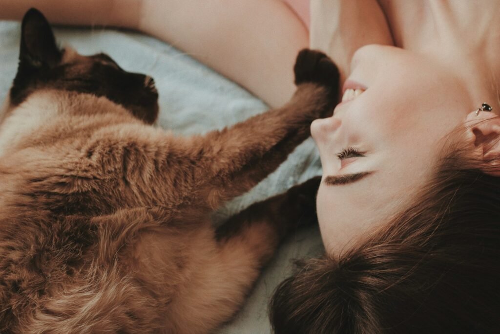 Cat Stress woman lying beside brown cat