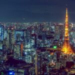 Stunning aerial view of Tokyo's vibrant cityscape with the illuminated Tokyo Tower at night.