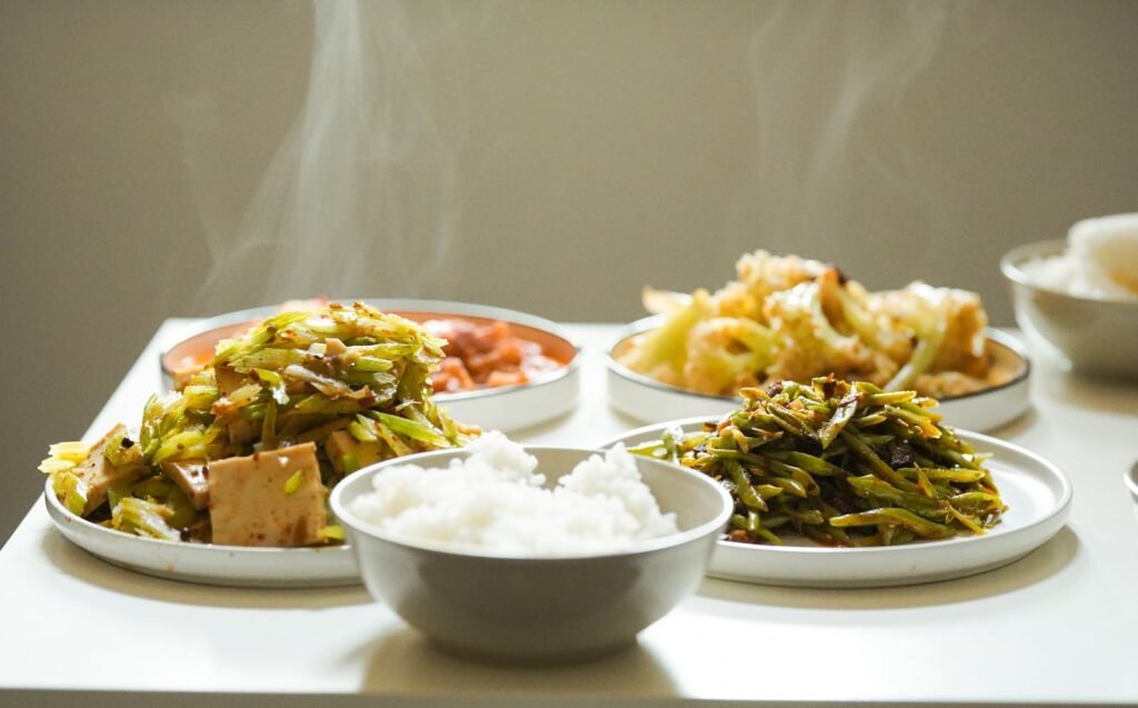 Capture of steaming Asian dishes featuring a variety of fresh vegetables, perfect for a healthy meal.