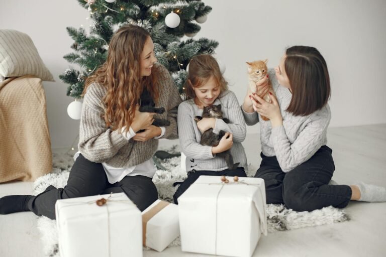 A family with children and cats celebrating Christmas by the tree with gifts.
