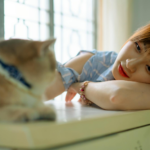 A woman enjoying a serene moment with her cat, indoors. Perfect depiction of companionship and relaxation.