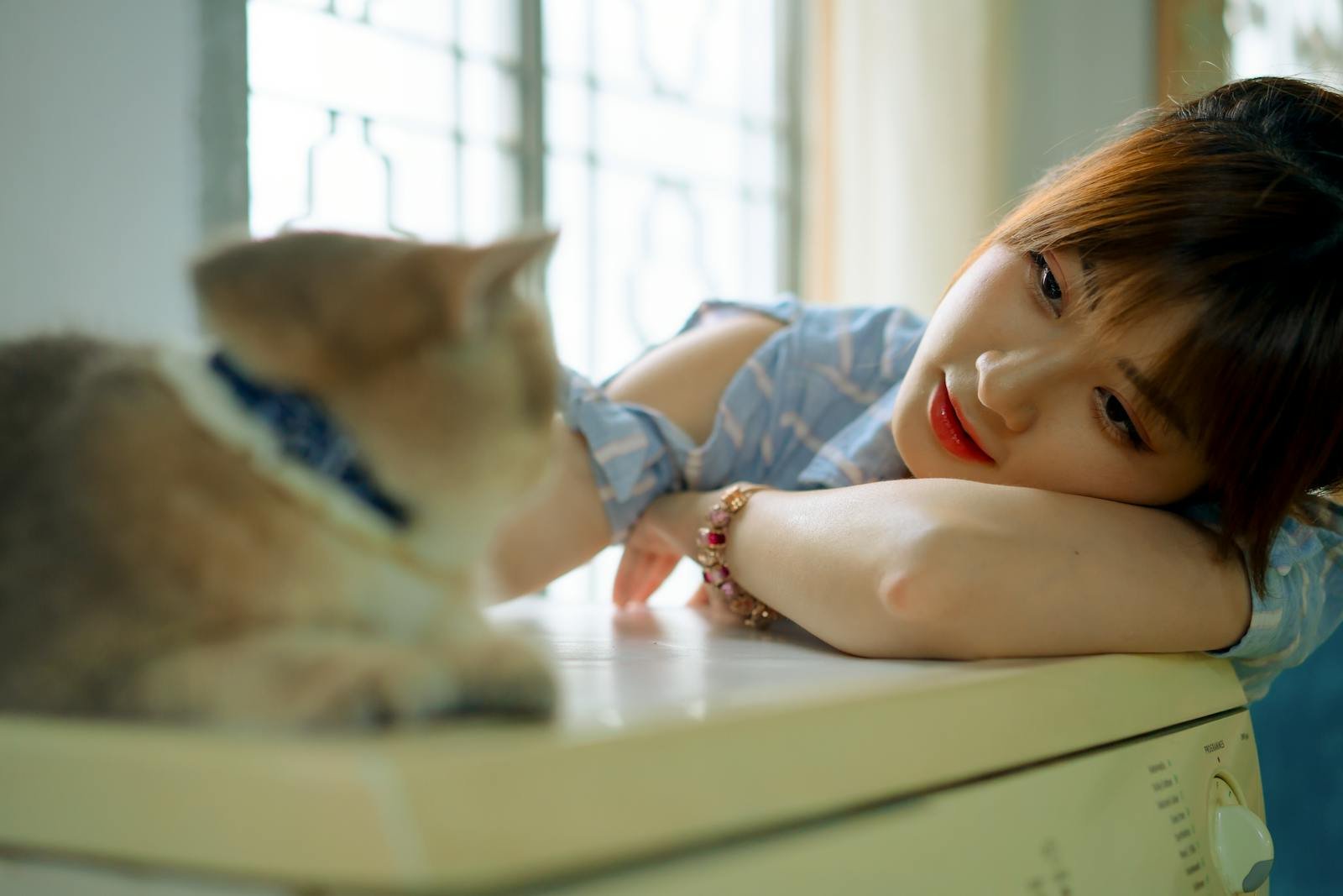 A woman enjoying a serene moment with her cat, indoors. Perfect depiction of companionship and relaxation.