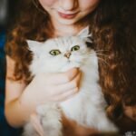 woman holding white cat