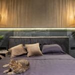 A serene bedroom scene with a relaxing cat, elegant lighting, and plush cushions.