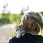 a woman holding a small kitten in her arms